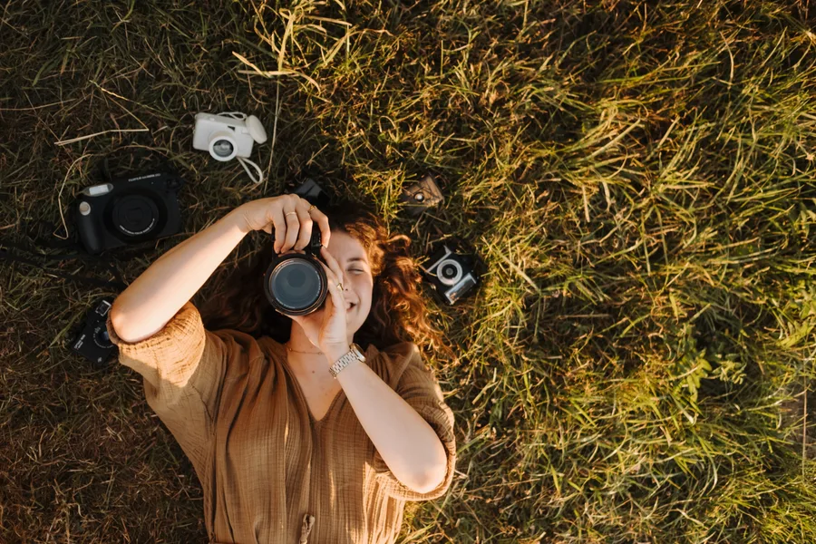 Clarissa Chesterton im Gras, umgeben von ihren Kameras